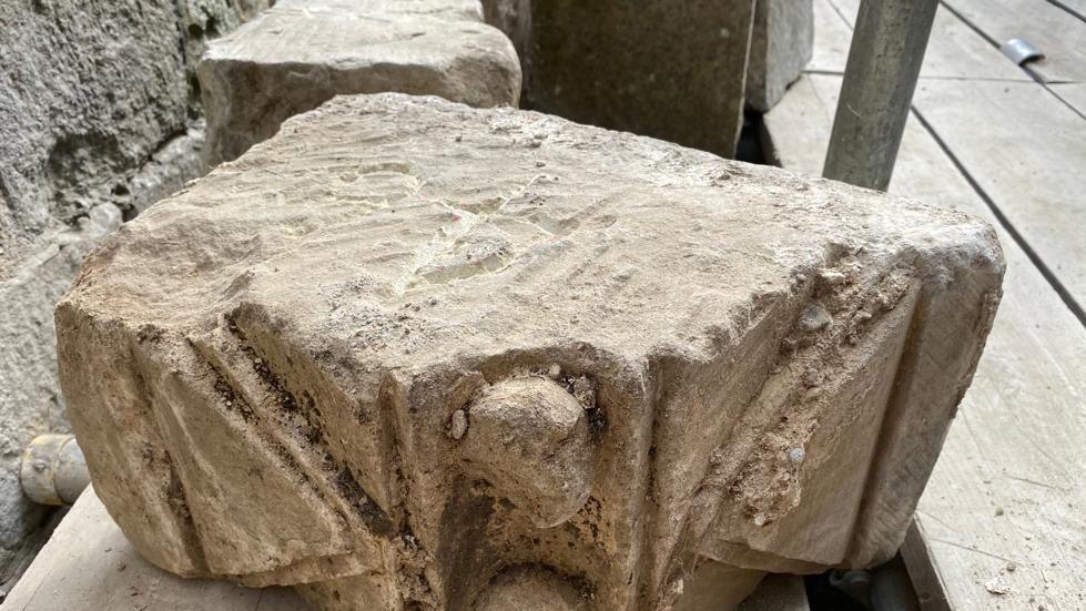 A decorated stone placed on wooden scaffolding walkway.