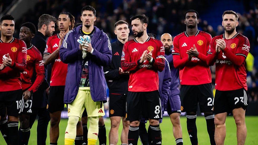Manchester United players applauding towards their supporters