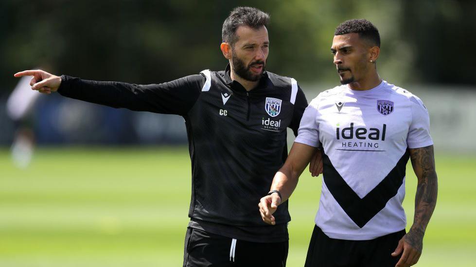 Karlan Grant gets instructions from head coach Carlos Corberan during a West Brom training session