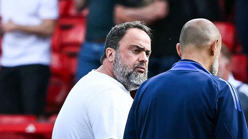 Evangelos Marinakis looks and walks with Nuno Espirito Santo after game
