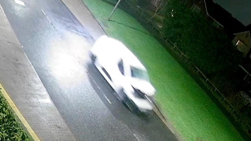 A CCTV still of a white van with a crumpled bonnet and smashed windscreen