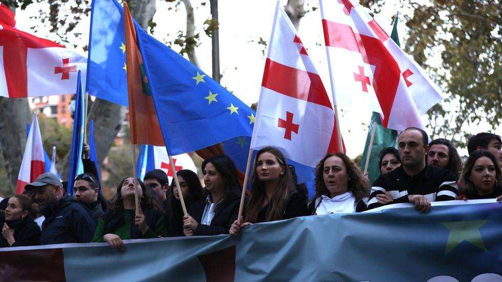 Thousands of people, waving European Union (EU), Georgian and Ukrainian flags take part in a rally on 20 October in Tbilisi