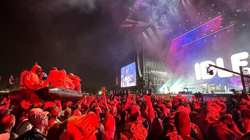 The inflatable raft carrying dummies dressed as migrants 'crowdsurfing' during the Idles gig at Glastonbury Festival.