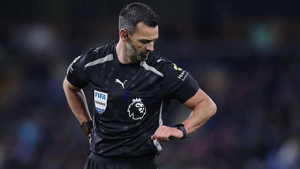 Referee Andrew Madley checks his watch during the Premier League match between Burnley and Manchester City 