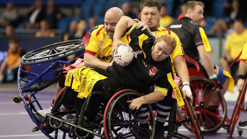 Jodie Boyd-Ward of Wales is tackled by Mike Mellon of Scotland during the Wheelchair Rugby League World Cup in 2022 