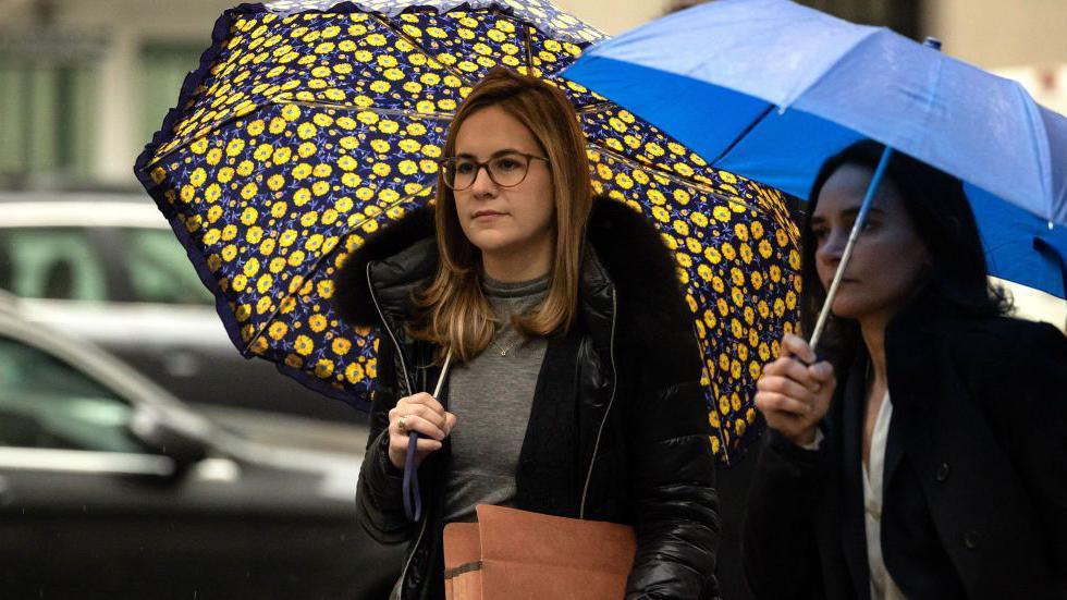 Danielle Sassoon holds an umbrella