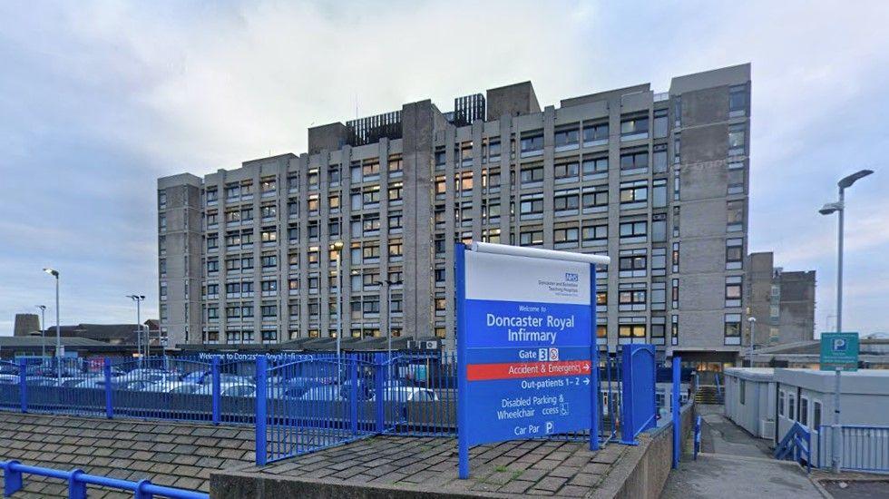 A picture of the main building of Doncaster Royal Infirmary. It is a large grey concrete building. It is eight storeys high and has 18 rows of windows