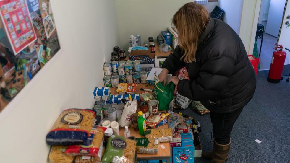 A volunteer with Community for Food unpacks donations from Morrisons supermarket at its centre in Edinburgh