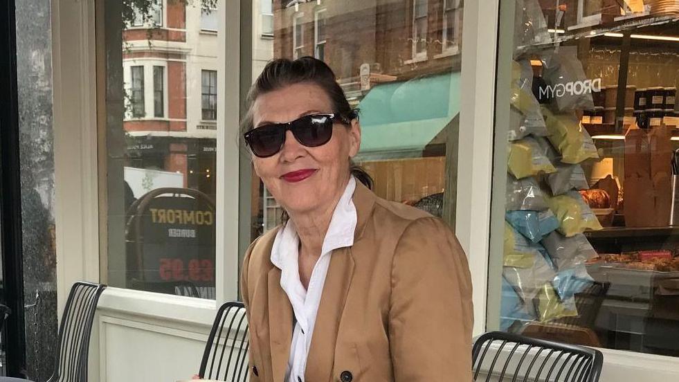 A woman with sunglasses on sitting on a chair