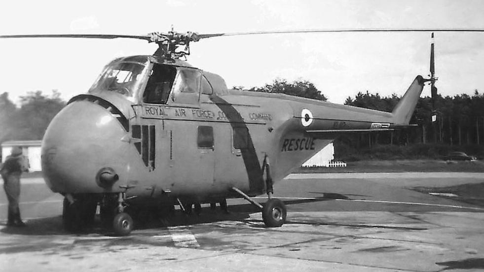A black and white photograph of an RAF helicopter on a runway.