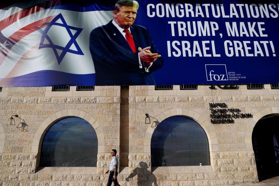 A man walks past a large billboard congratulating US President-elect Donald Trump, on the facade of Friends of Zion Museum in Jerusalem, 07 November 2024.