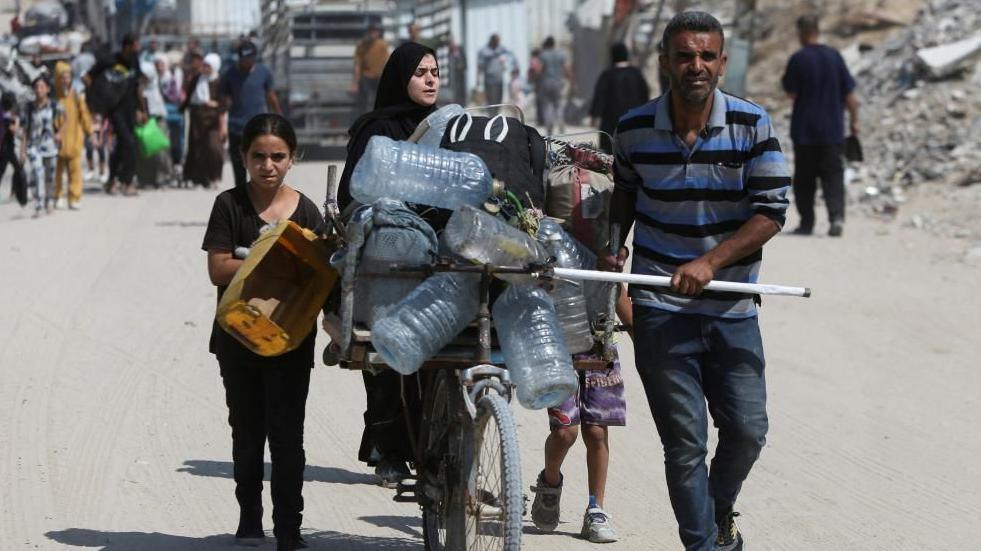Palestinians carrying supplies on a road in Gaza