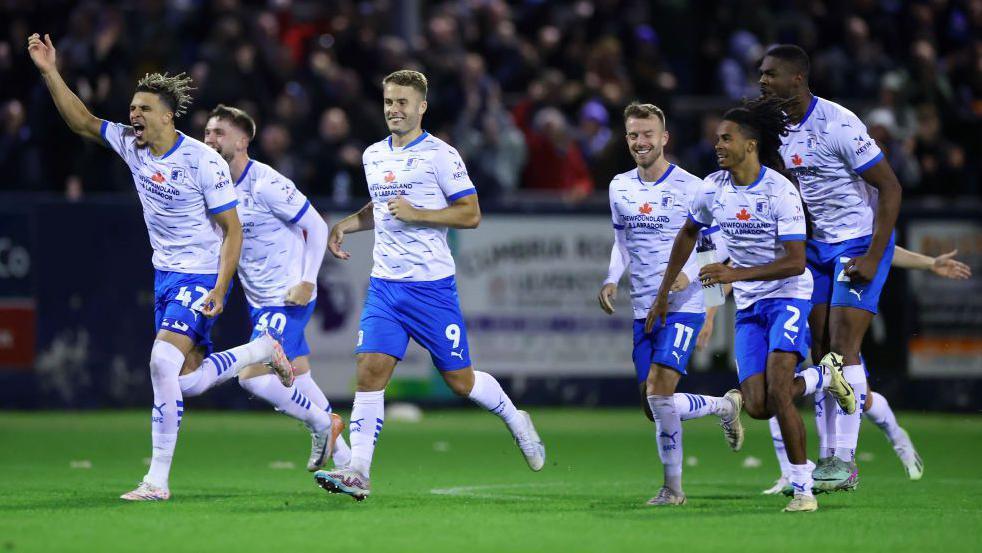 Barrow players celebrate beating Derby on penalties