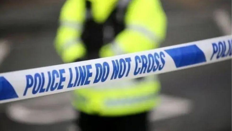 A stock image showing a police cordon and a police officer stood inside the cordon.