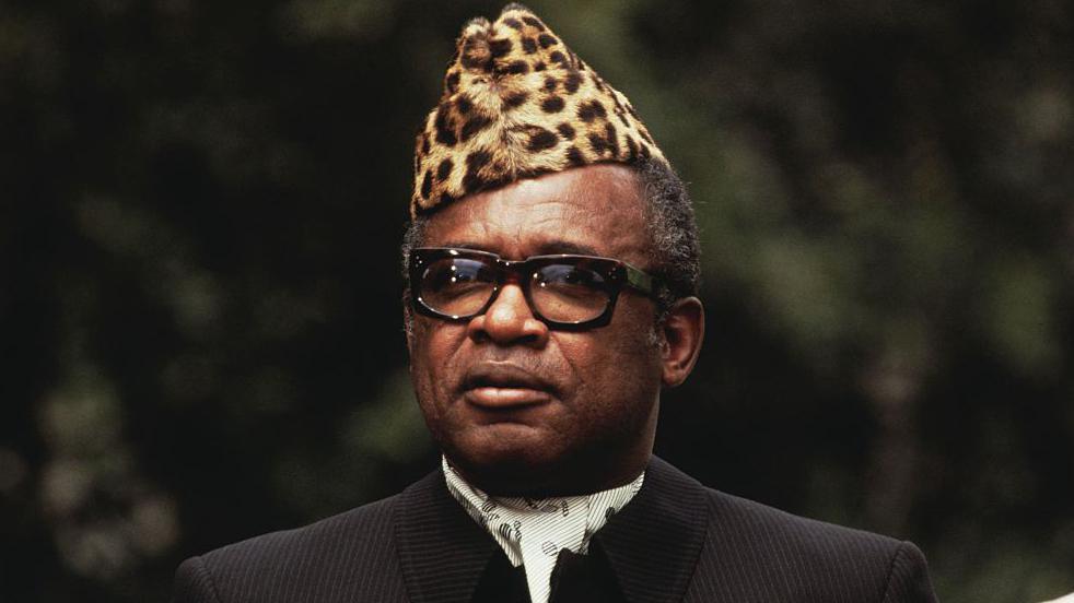 Former President of the Democratic Republic of Congo Mobutu Sese Seko wearing a leopard-skin hat, glasses and a dark suit and cravat