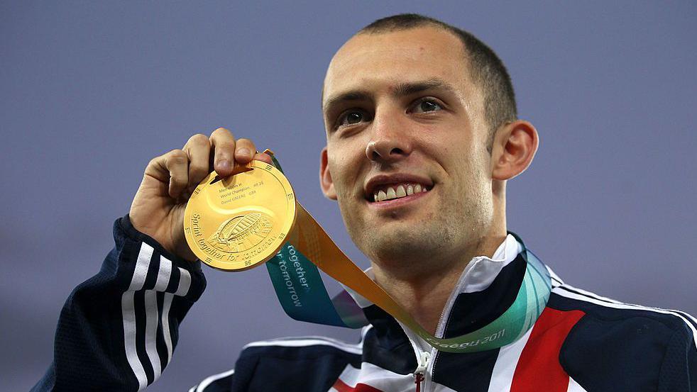 David Greene poses with his gold medal during the medal ceremony 