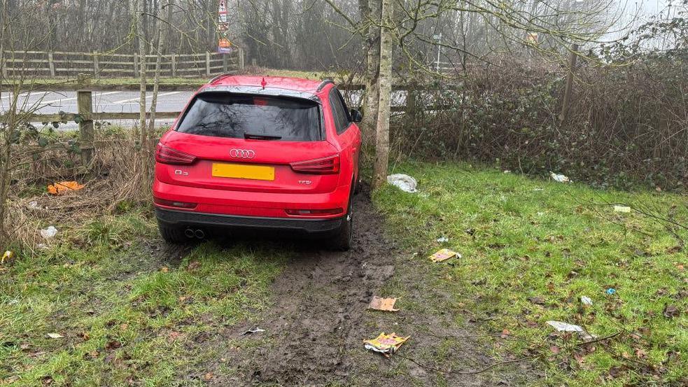 An image of a red Audi car that has crashed into a grass verge in Derbyshire