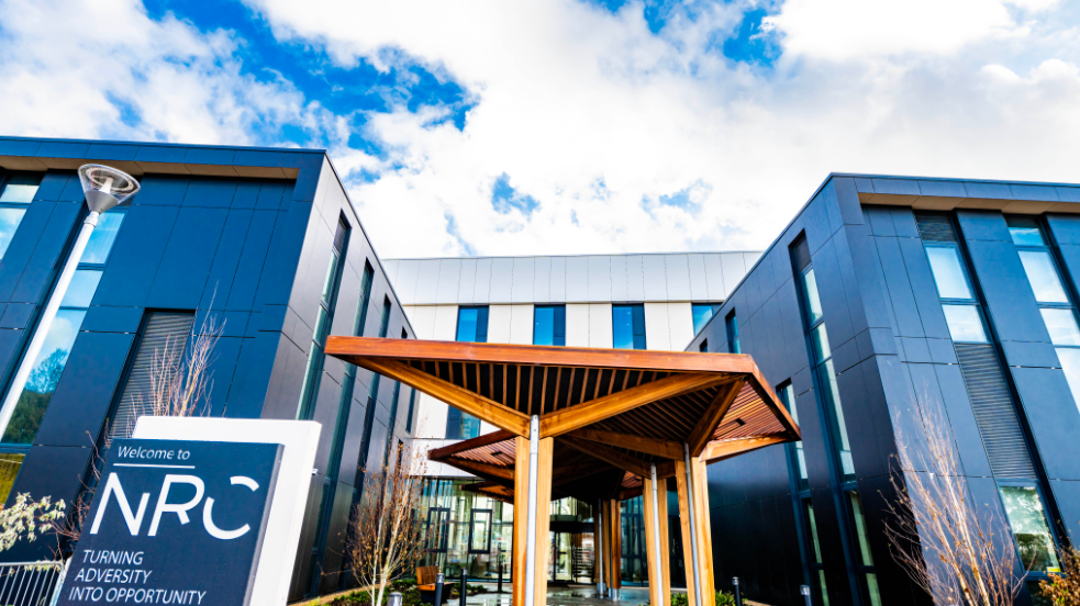 A wooden structure out the front of a new rehabilitation centre with black and white cladding