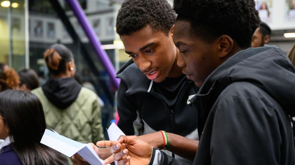 Two boys looking at exam results 