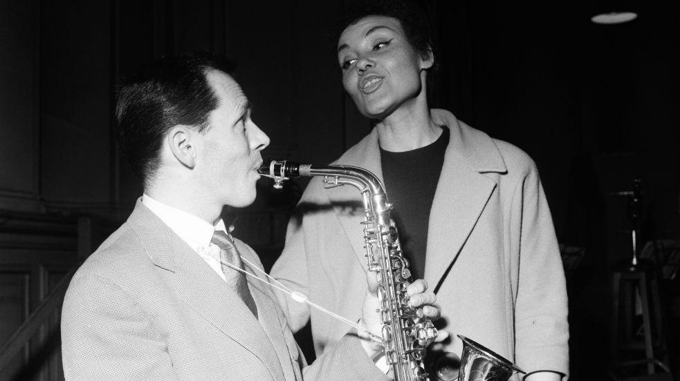 Cleo Laine and John Dankworth photographed in the 1950s; he is playing a saxophone and she is singing