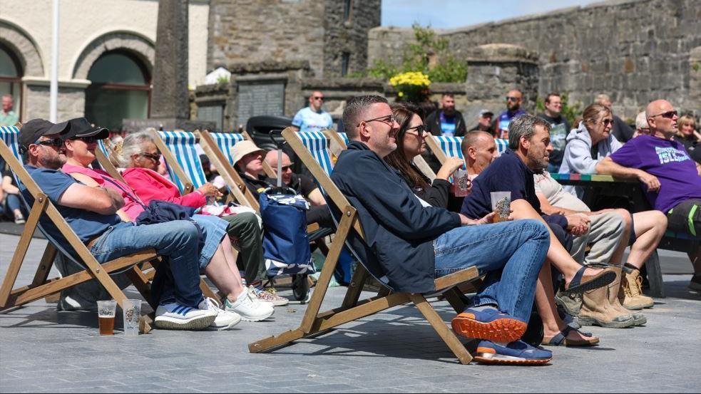Fans sitting in blue and white striped deck chairs in Market Square.