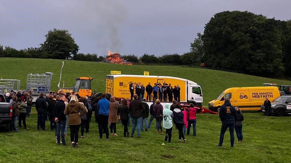 Supporters of the Enough is Enough farmers' pressure group with vehicles and a bonfire on a farm