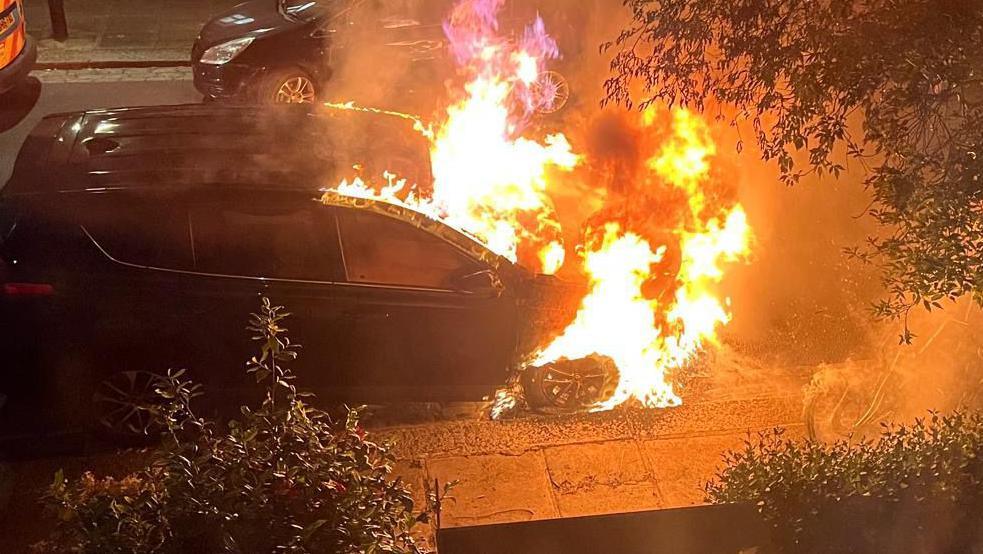 A still from a video showing a car on fire