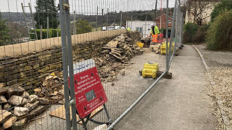 Subsidence on he road has led to a wall collapsing