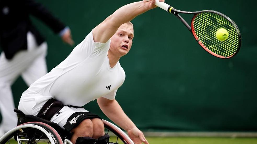 Wheelchair Tennis star Ben Bartram plays a tennis stroke at Wimbledon