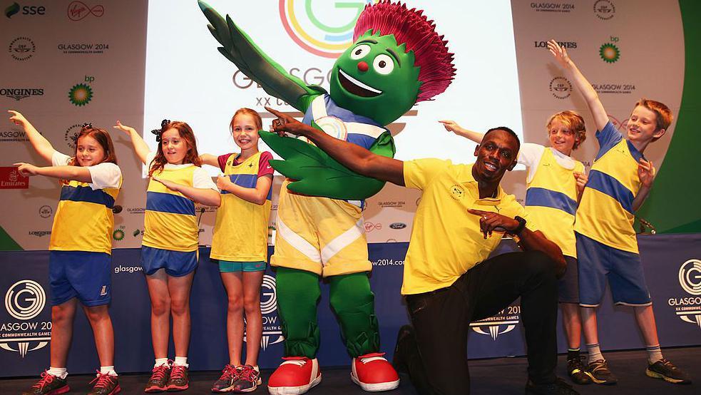 Usain Bolt pulls a pose with schoolchildren and the Glasgow 2014 mascot