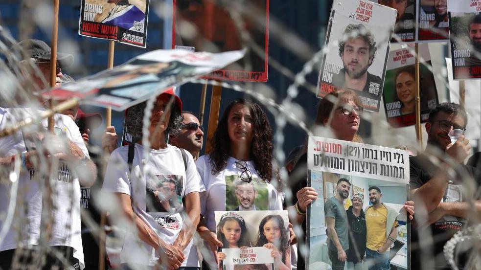 Families of Israeli hostages holding their pictures at a rally demanding their release