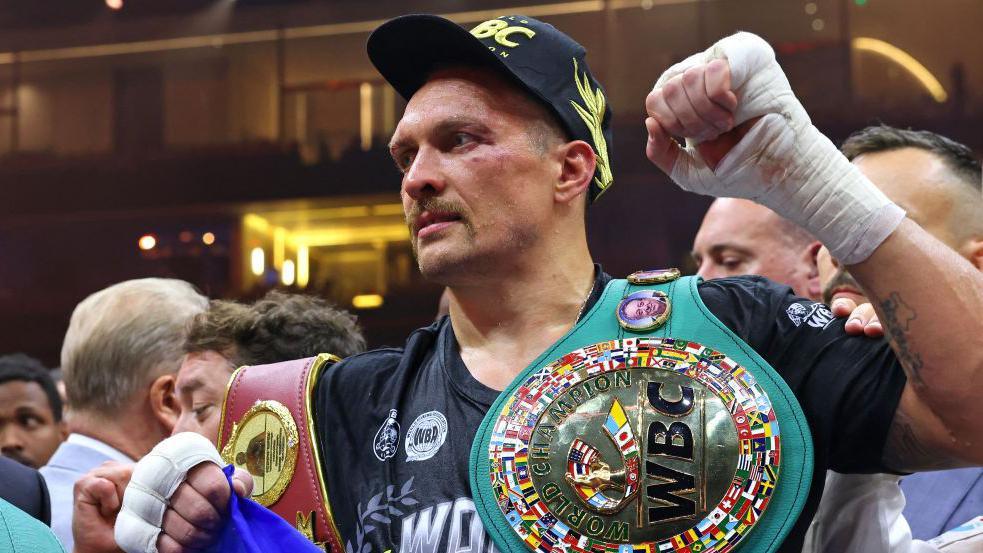 Oleksandr Usyk from Ukraine (C) celebrates his win over Britain's Tyson Fury during a heavyweight boxing world championship match at Kingdom Arena in Riyadh