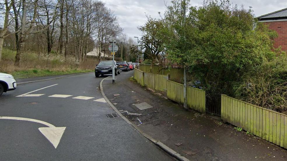 A street view of a roundabout on Counthill Road in Oldham on an overcast day.