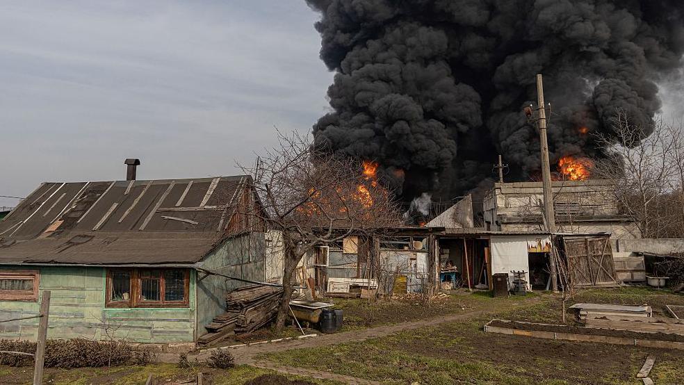 This photograph shows buildings on fire following a strike on the outskirts of Odessa on 11 March 2025.