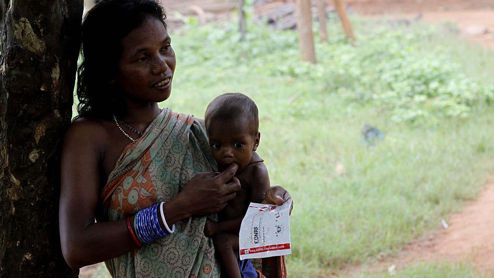 Villagers and village living children look at the Nagada village inside the Nagada Hills in Jajpur district near by 150 km away from the eastern Indian state Odishas capital city Bhubaneswar, India on 30 July 2016