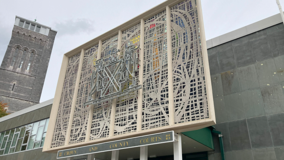 The front of the Plymouth Crown Court building on a grey day. A sign reads CROWN AND COUNTY COURTS and above it is an elaborately designed set of windows.