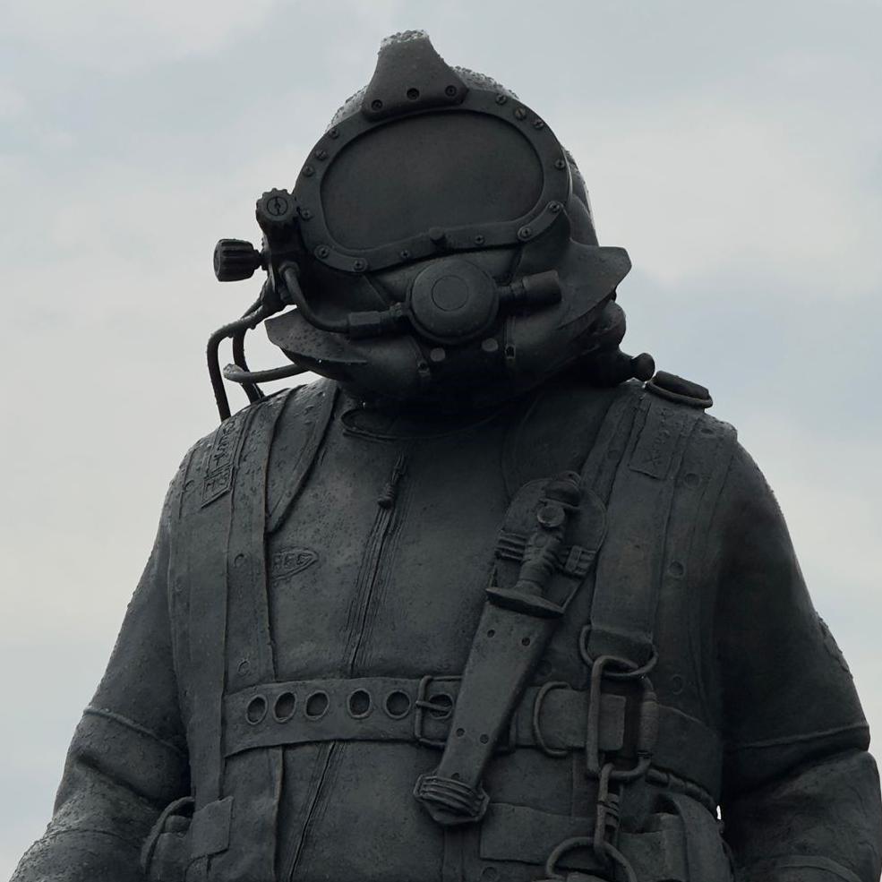 A close up image of a sculpture, by Alan Herriot, depicting a deep sea diver, which has been installed on the quayside at Aberdeen Harbour.