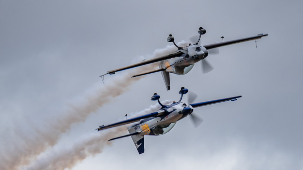 Two light propeller plans shown flying in unison, upside-down