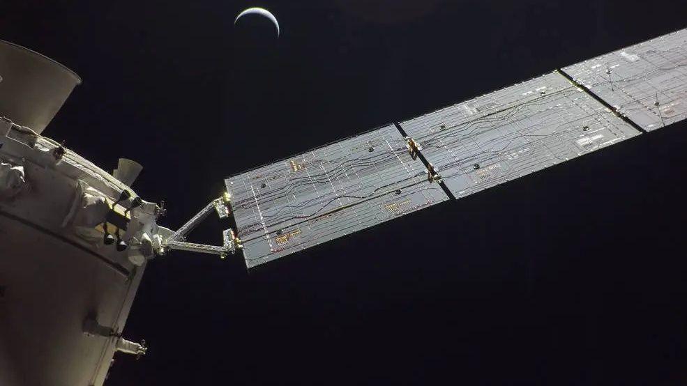 A photo of the Orion spacecraft that it took itself with the moon in the distance