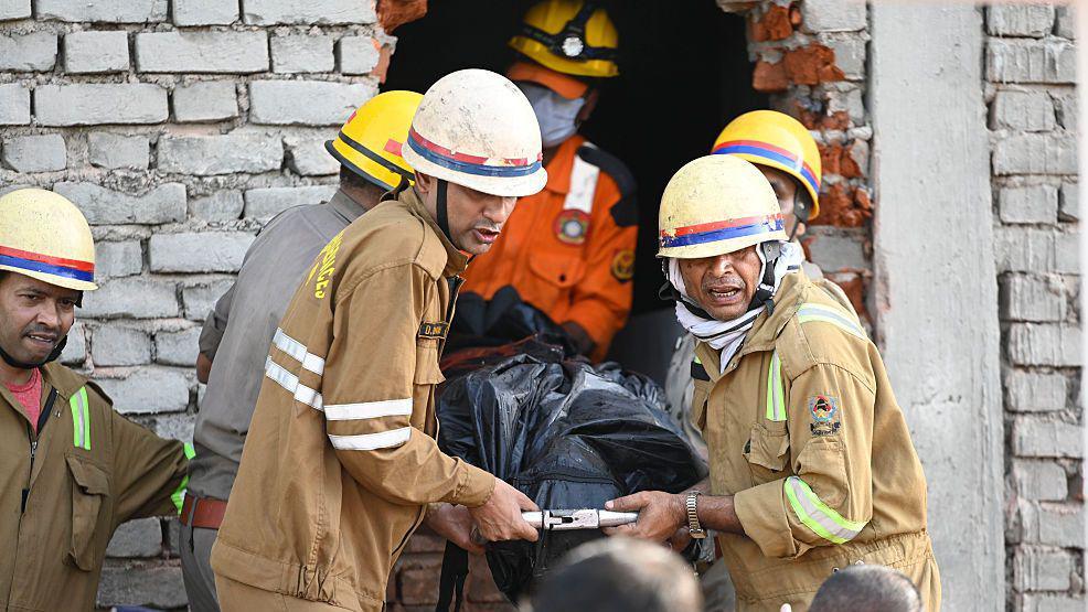 Firefighters and State Disaster Response Force teams recover the bodies of victims after a massive fire broke out inside a three-floor commercial building.