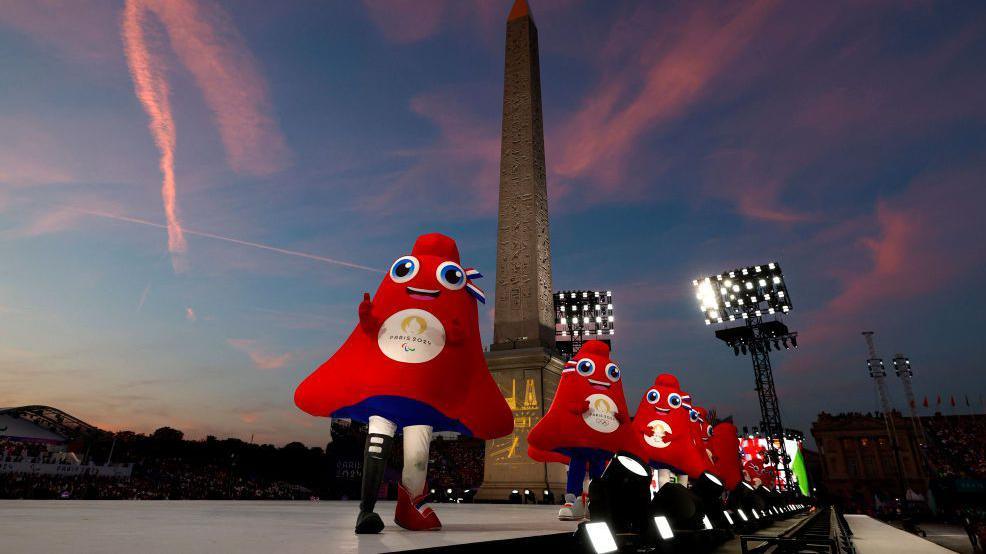 The Paralympic mascot the Phryge, with a running blade, performing at the Place de la Concorde