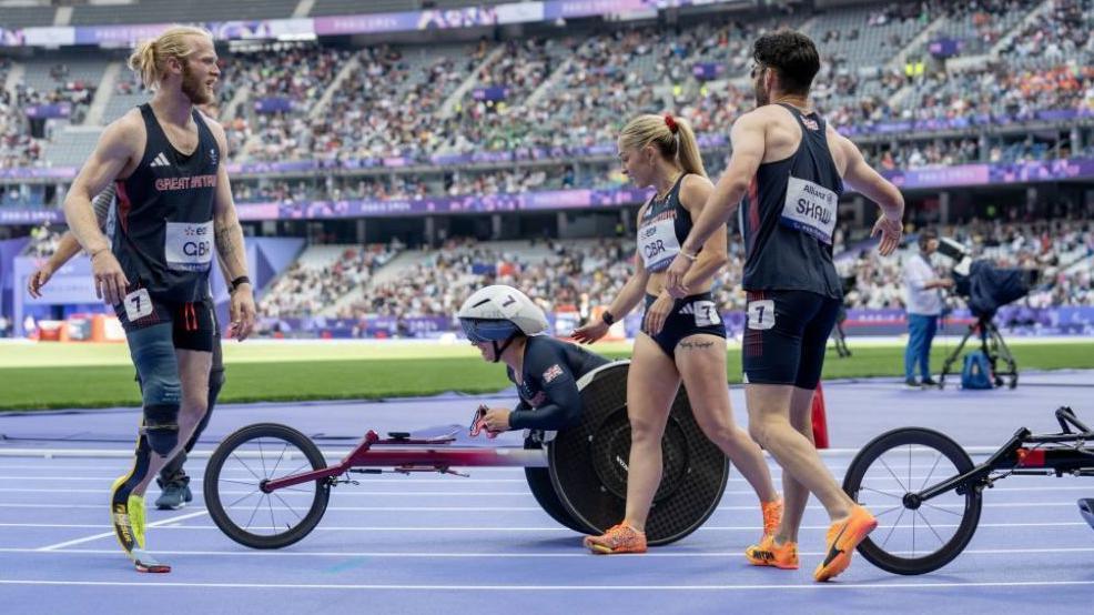 Samantha Kinghorn, Jonathan Peacock, Zachary Shaw and Alison Smith at the end of the 4x100m Universal Relay in Paris. In the background, are stands full of spectators