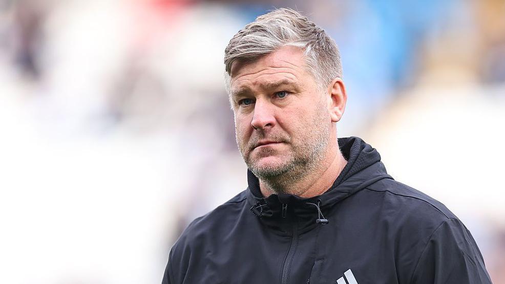 Salford City manager Karl Robinson looks serious on the touchline