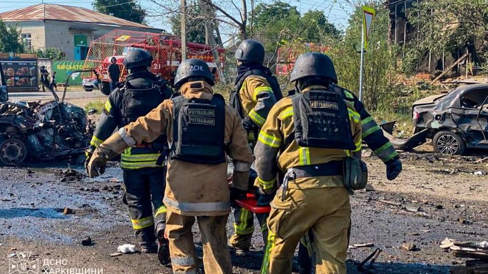 Rescuers carry a person killed during Russian drone strikes in the town of Pechenihy, amid Russia's attack on Ukraine in Kharkiv region, Ukraine August 18, 2026
