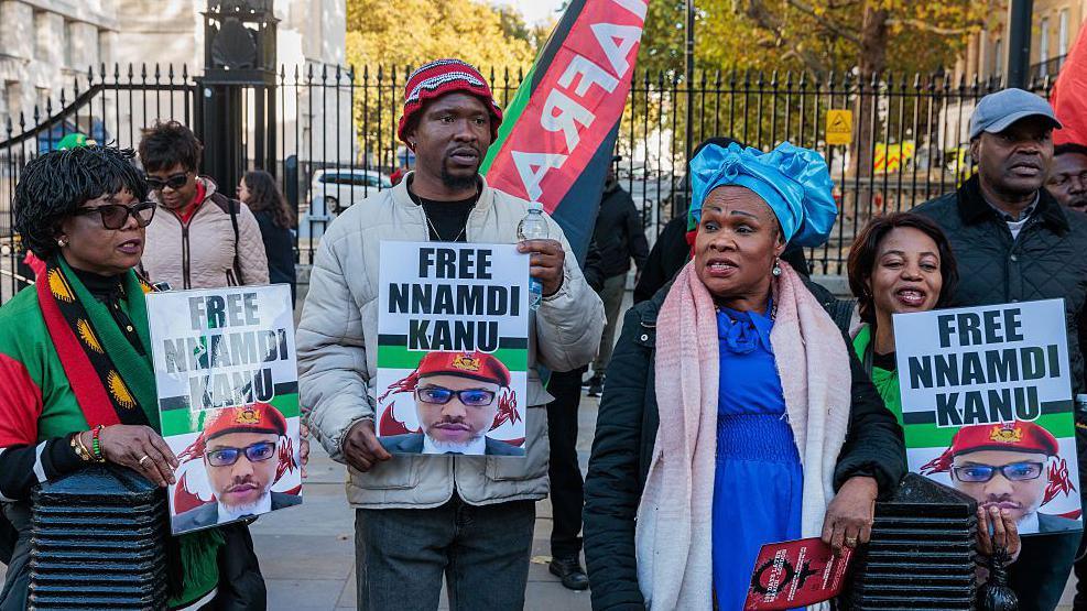 A group pf men and women hold placards saying: Free Nnamdi Kanu
