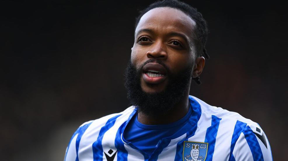Nathaniel Chalobah looking forward, wearing Sheffield Wednesday home kit of blue and white stripes