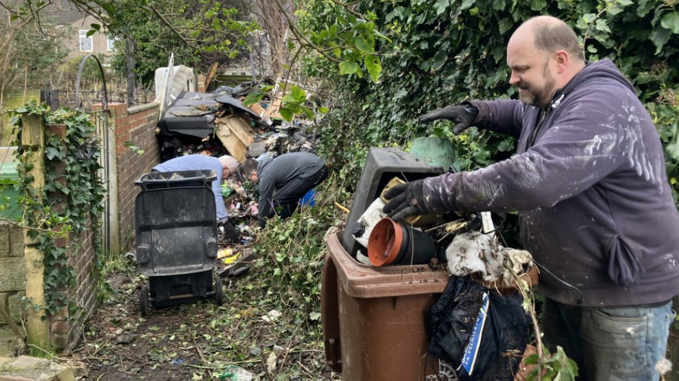 Resident David Page clears up alleyways near his home