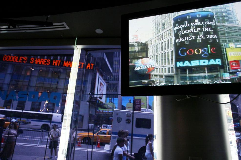Logoja e Google shfaqet në një ekran dhe një shenjë brenda faqes së tregut NASDAQ pak para mbylljes së tregjeve më 19 gusht 2004 në New York City.