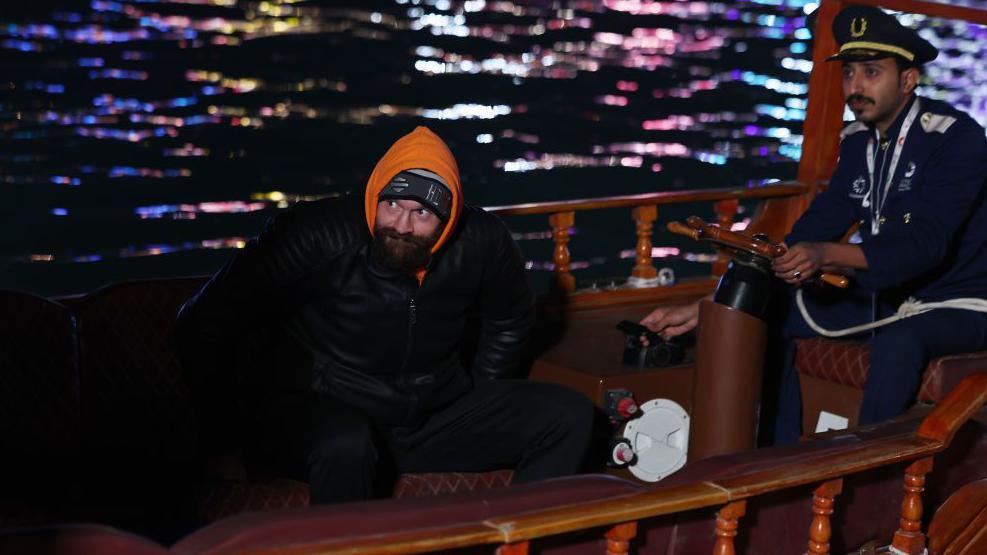 Tyson Fury arrives to a media event in a boat