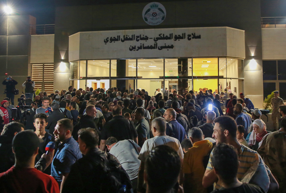 People evacuated from Sudan arrive at a military airport in Amman on April 24, 2023